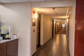 A hotel hallway with a coffee machine and a fire alarm on the wall. - Clarion Pointe Racine - Mount Pleasant (Mount Pleasant)