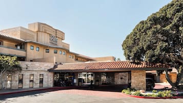A building with a sign reading 'FOUR POINTS BY SHERATON' and a covered entrance with a tiled roof.