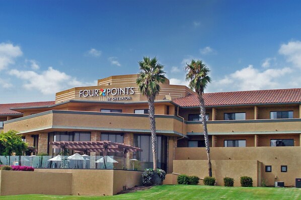 A hotel with a sign reading 'FOUR POINTS BY SHERATON' and a covered outdoor seating area with umbrellas. - Four Points by Sheraton Ventura Harbor Resort (Ventura)