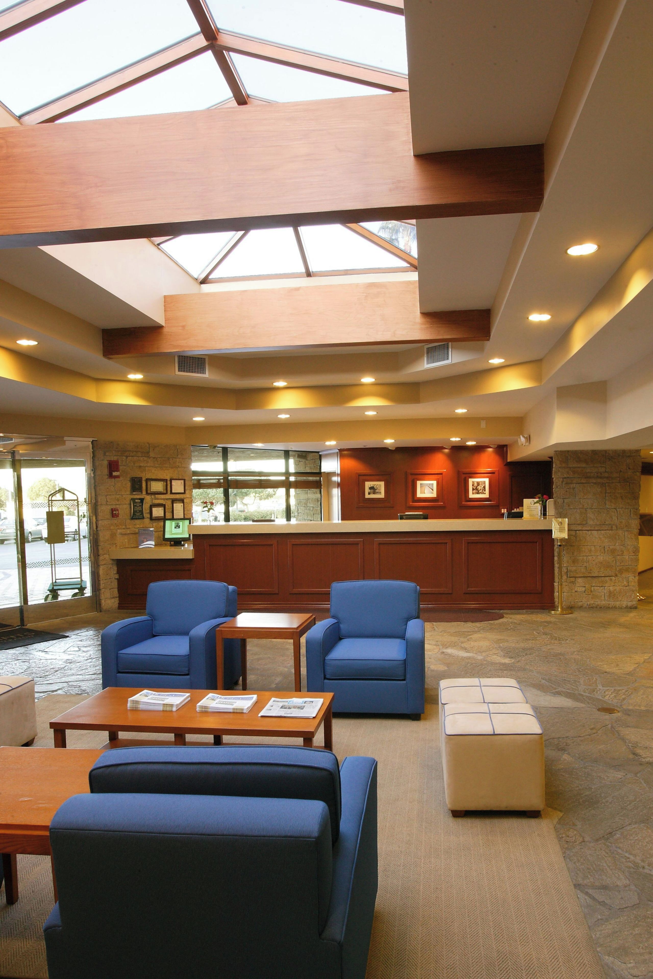 A spacious lobby with a high ceiling, a reception desk, and seating area.