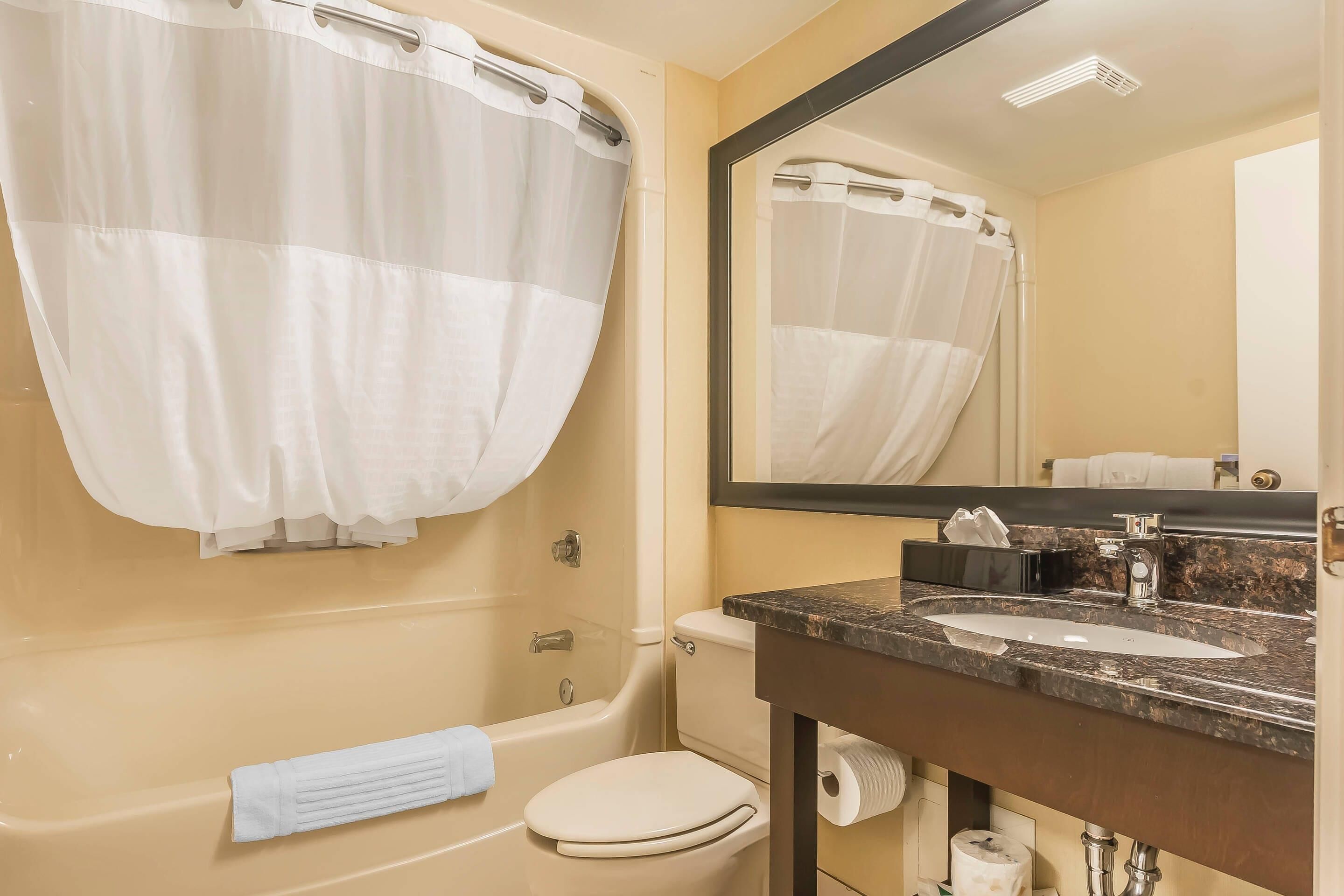 A bathroom with a bathtub, toilet, and sink.