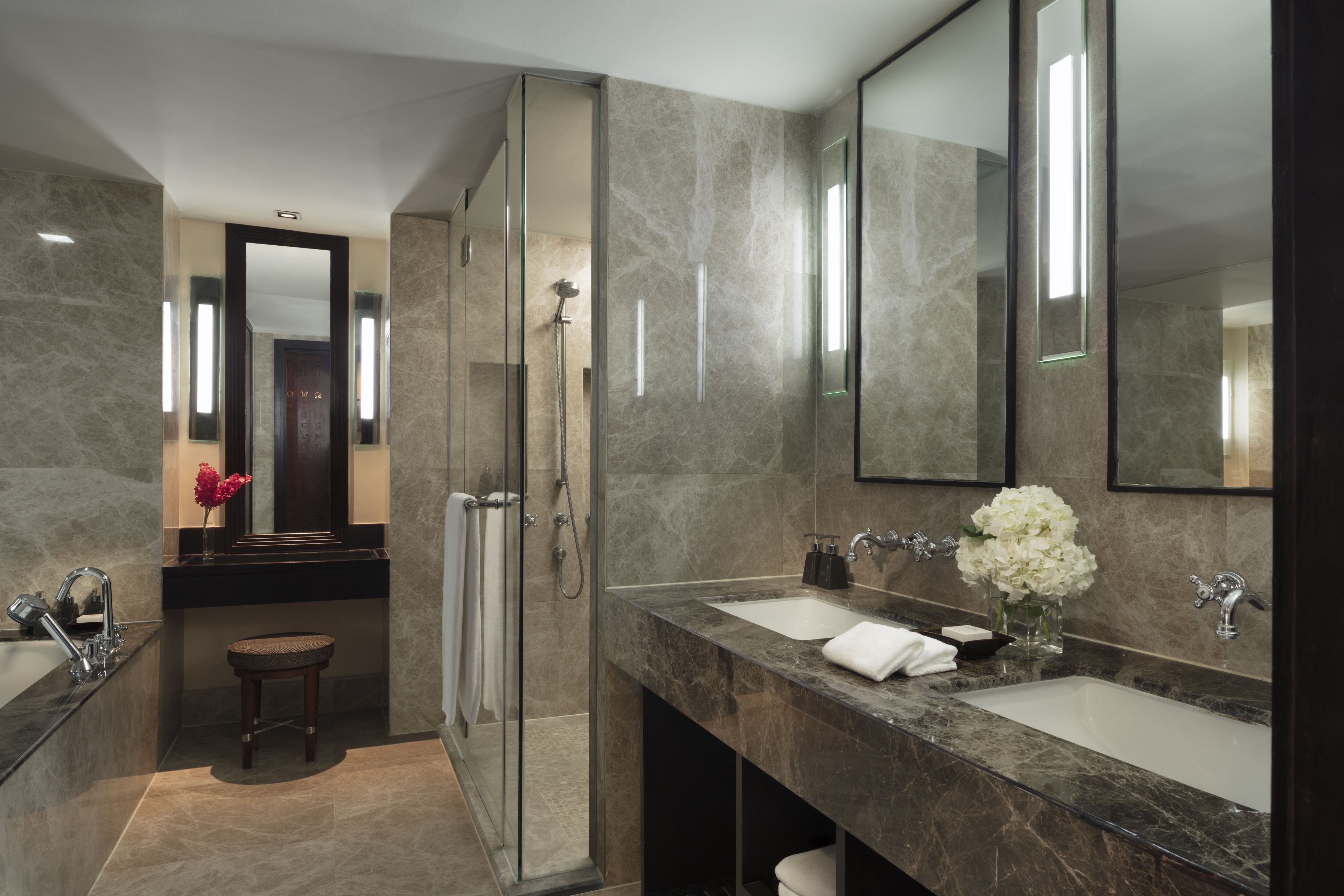 A modern bathroom with a glass-enclosed shower, two sinks, and a large mirror.