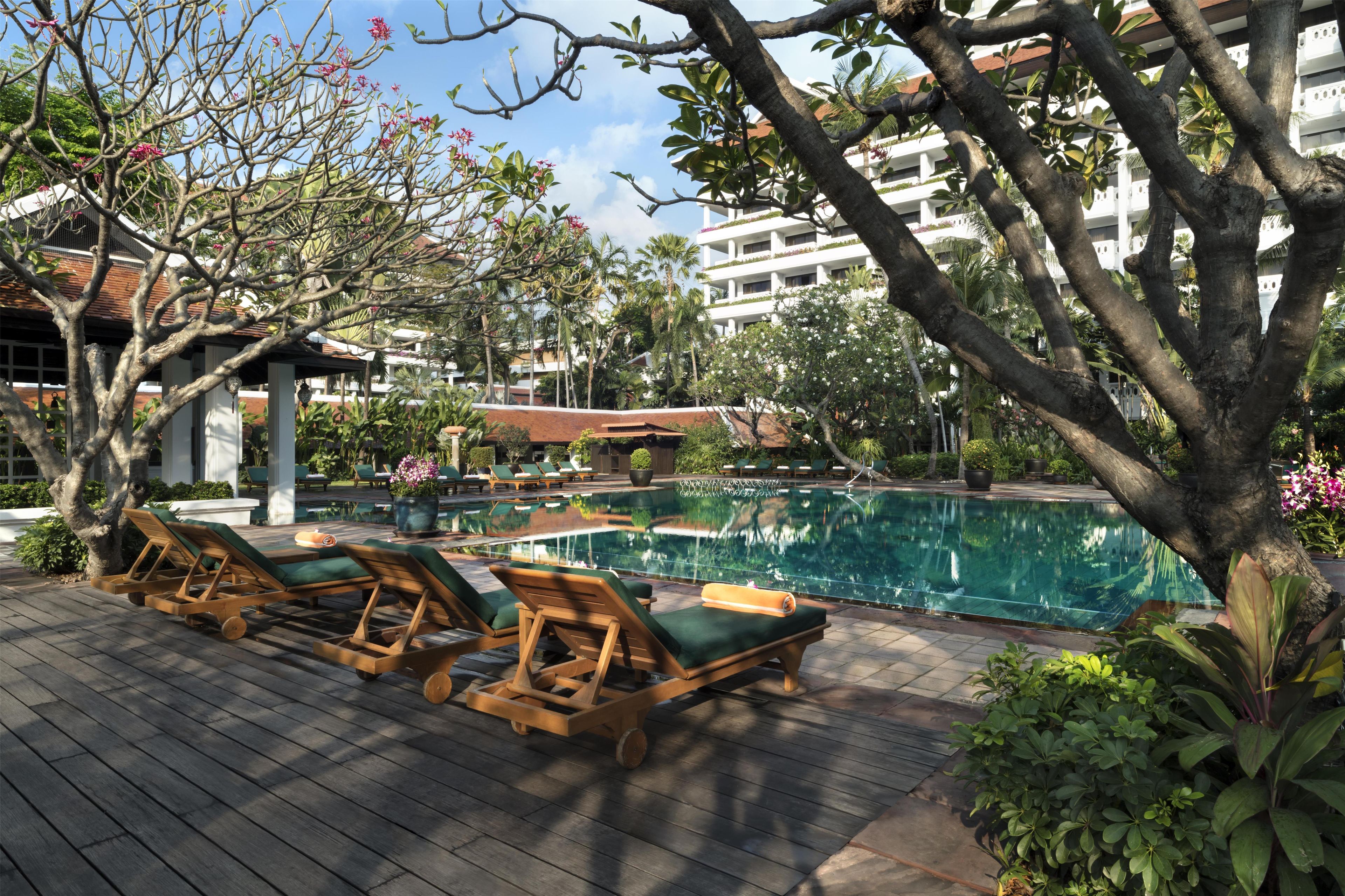 A poolside area with lounge chairs and a clear pool.