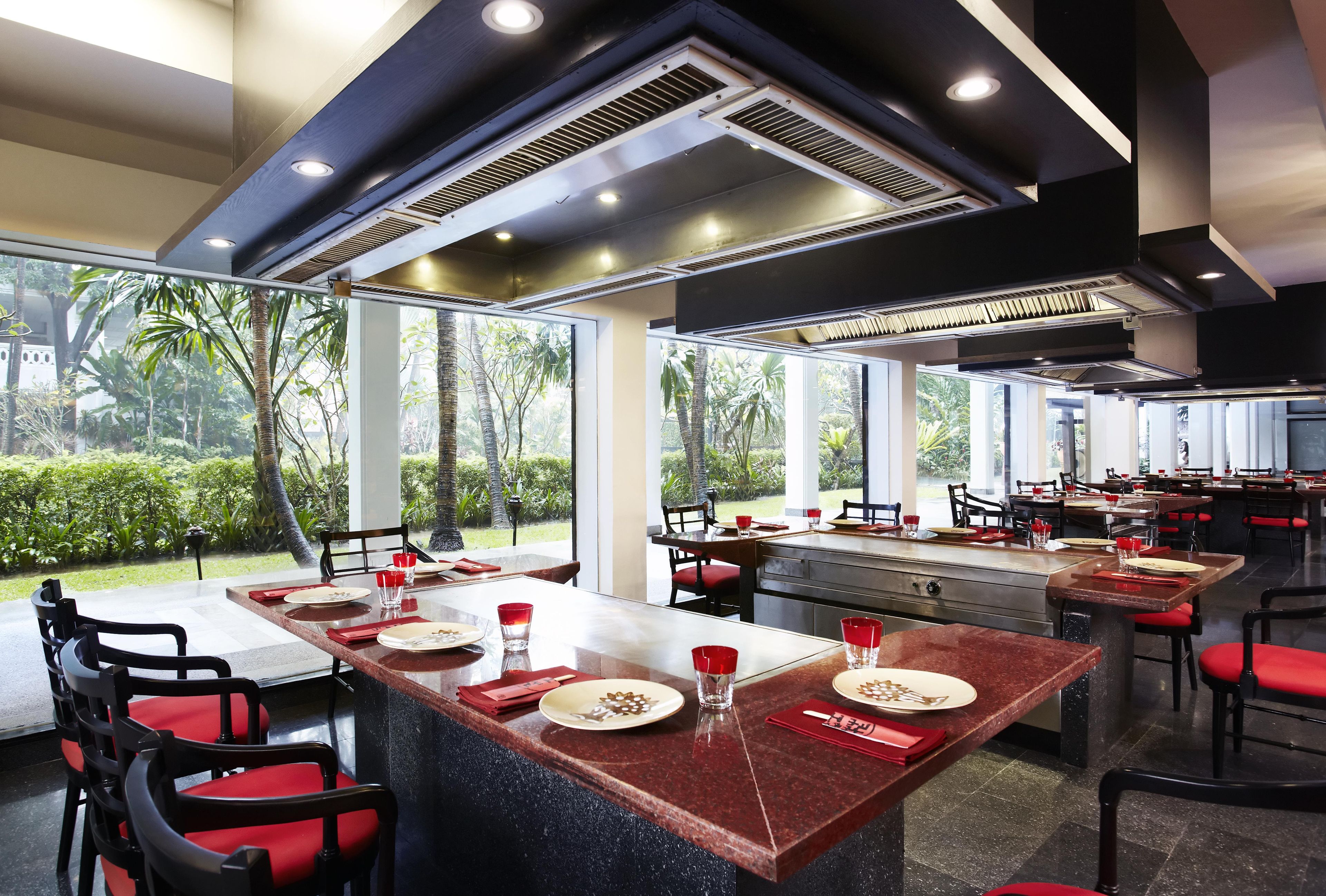 A restaurant with outdoor seating, large windows, and a modern interior design.