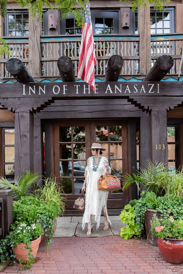 The exterior of the Inn of the Anasazi with a wooden facade, large windows, and a number '113' on the door. - Rosewood Inn of the Anasazi (Santa Fe)
