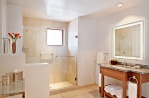 A modern bathroom with a glass-enclosed shower, a large mirror, and a vanity with a marble countertop. - Rosewood Inn of the Anasazi (Santa Fe)