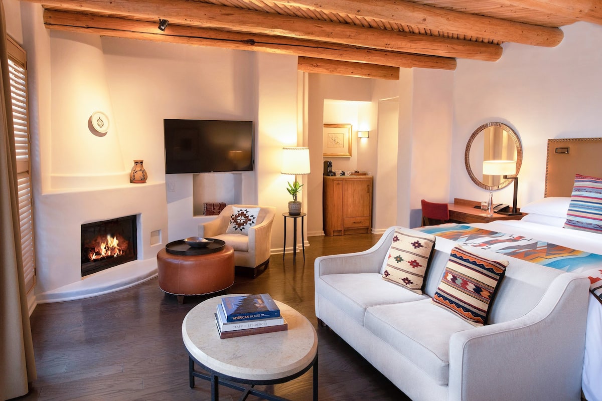Una sala de estar acogedora con chimenea, un sofá, una mesa de centro y un televisor.