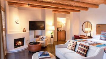 Una sala de estar acogedora con chimenea, un sofá, una mesa de centro y un televisor.
