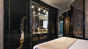 Une chambre d’hôtel moderne avec un grand lit, une coiffeuse avec un miroir et un dressing.