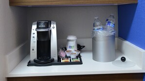 A kitchenette with a microwave, coffee maker, and water bottles on a white countertop. - Holiday Inn Express & Suites Chicago North Shore - Niles by IHG (Niles)