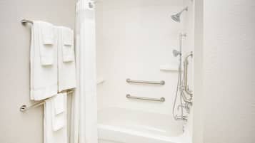 Un bagno con vasca, doccia e porta asciugamani.