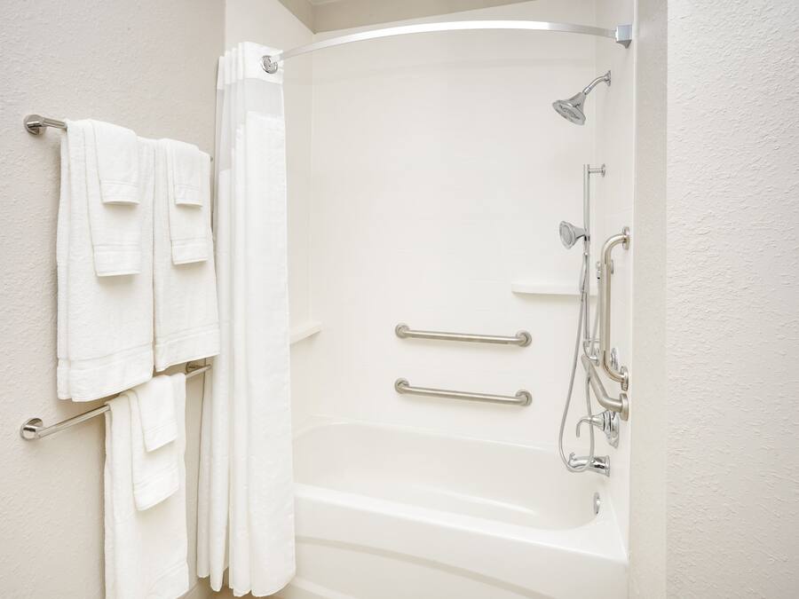 Un bagno con vasca, doccia e porta asciugamani.