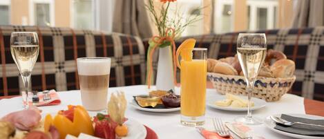 Una mesa con un desayuno variado, que incluye alimentos, bebidas y una cesta de pan.