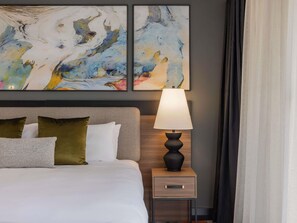 A hotel room with a bed, a nightstand with a lamp, and abstract art on the wall. - Mercure Brisbane Spring Hill (Spring Hill)