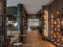Zona de bar con estante para vinos y asientos.