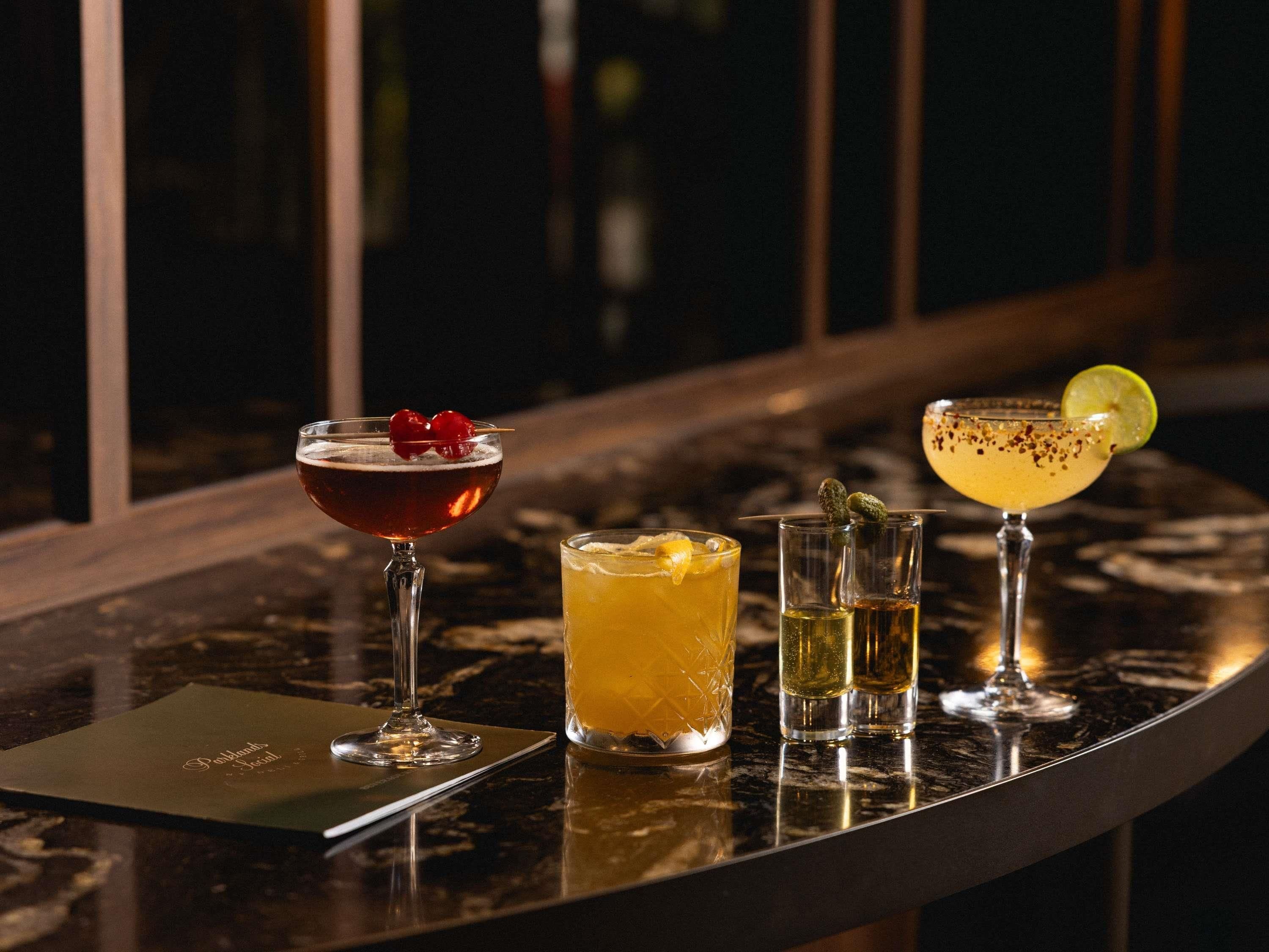 A bar area with a variety of drinks, a menu, and a view of the outside.