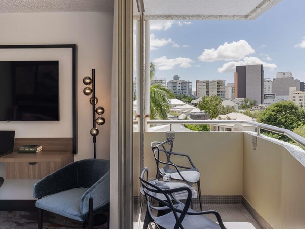 A balcony with a city view, a TV, a chair, and a table. - Mercure Brisbane Spring Hill (Spring Hill)