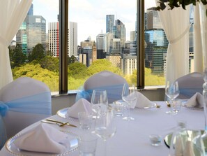 A table set for dining with a cityscape view through large windows.