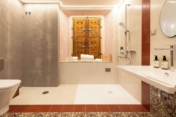 A modern bathroom with a toilet, a shower, and a sink area. - Hotel Carlos V (Toledo)