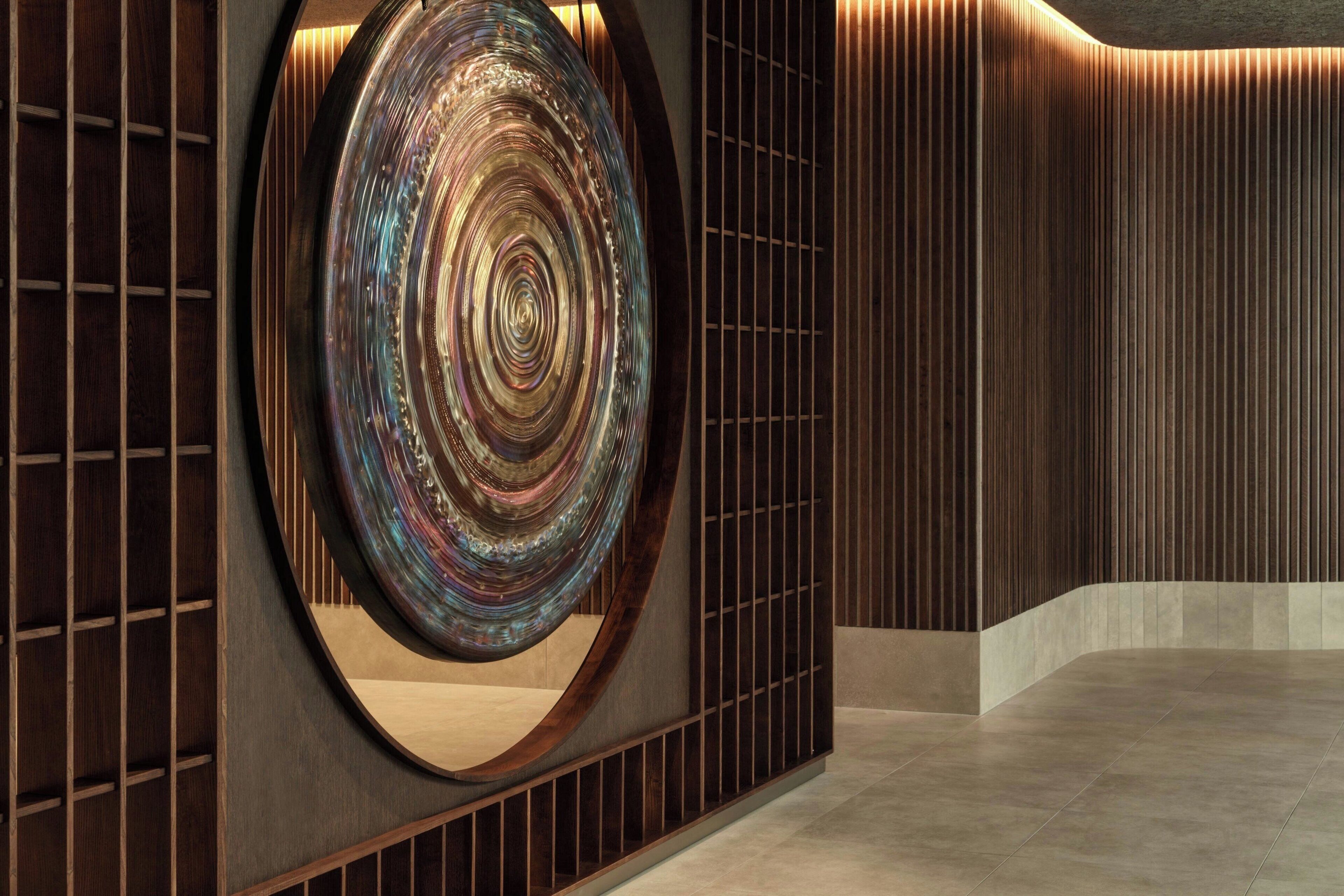 A modern interior with a circular decorative element, wooden paneling, and a tiled floor.