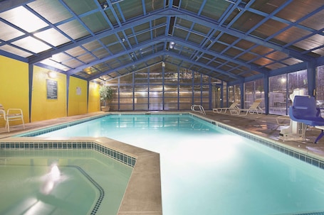 Una piscina techada, sillones reclinables de piscina