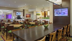 A modern dining area with multiple tables and chairs, a coffee station, and a TV screen. - Fairfield Inn & Suites by Marriott Belleville (Belleville)