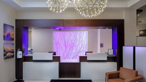 A reception area with two sinks, a welcome mat, a chair, and a decorative light fixture. - Fairfield Inn & Suites by Marriott Belleville (Belleville)