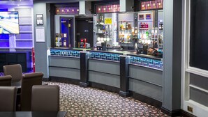 A bar area with a counter, seating, and a patterned carpet. - Britannia Hotel Manchester Airport (Manchester)