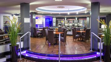 A modern bar area with a circular ceiling design, bar counters, and seating.