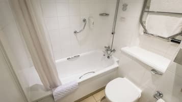 Un baño moderno con bañera, inodoro y perchero para toallas.