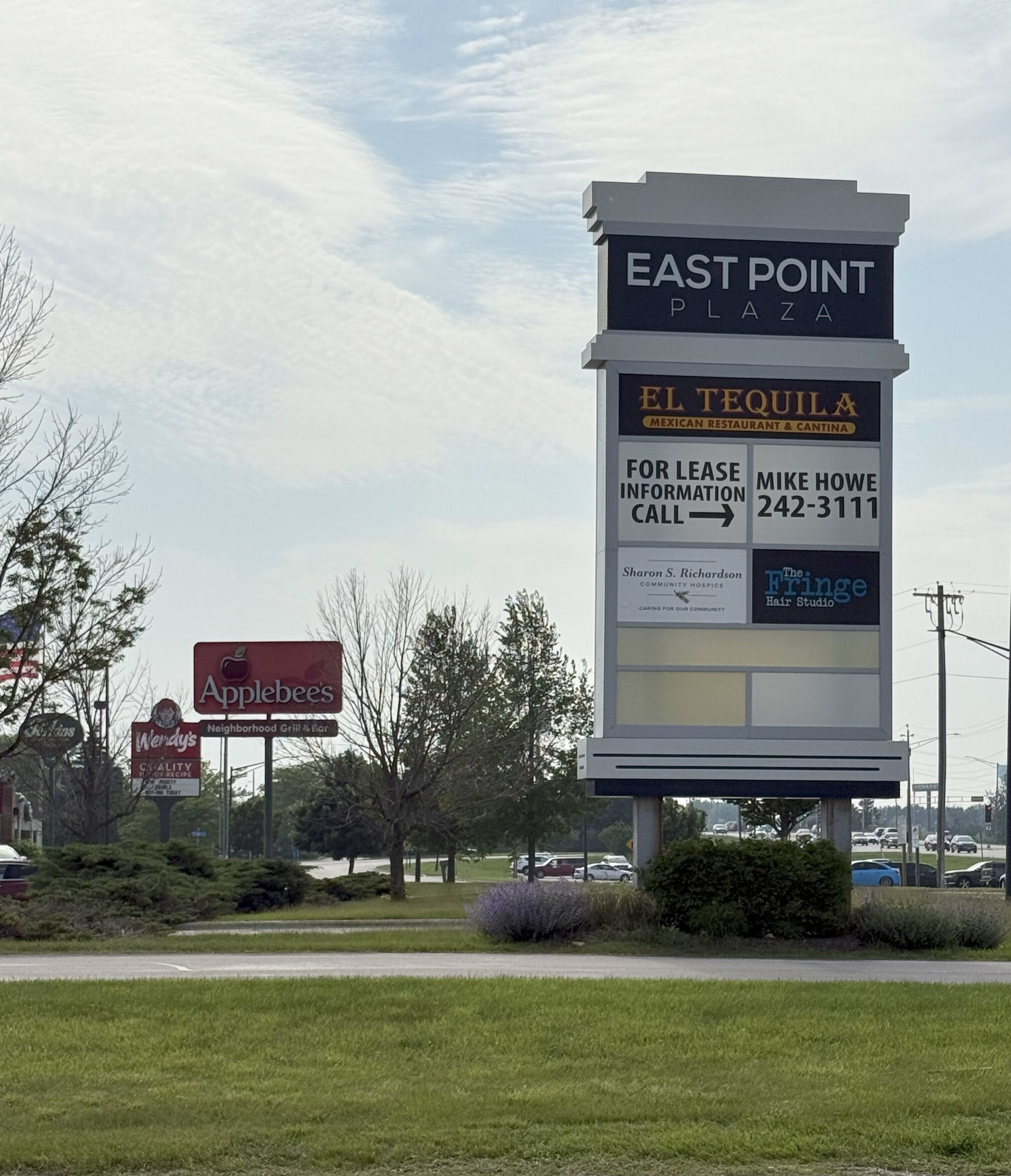 A commercial area with a large sign for East Point Plaza, featuring El Tequila Mexican Restaurant & Cantina, and other businesses like Applebee's and The Fringe Hair Studio.