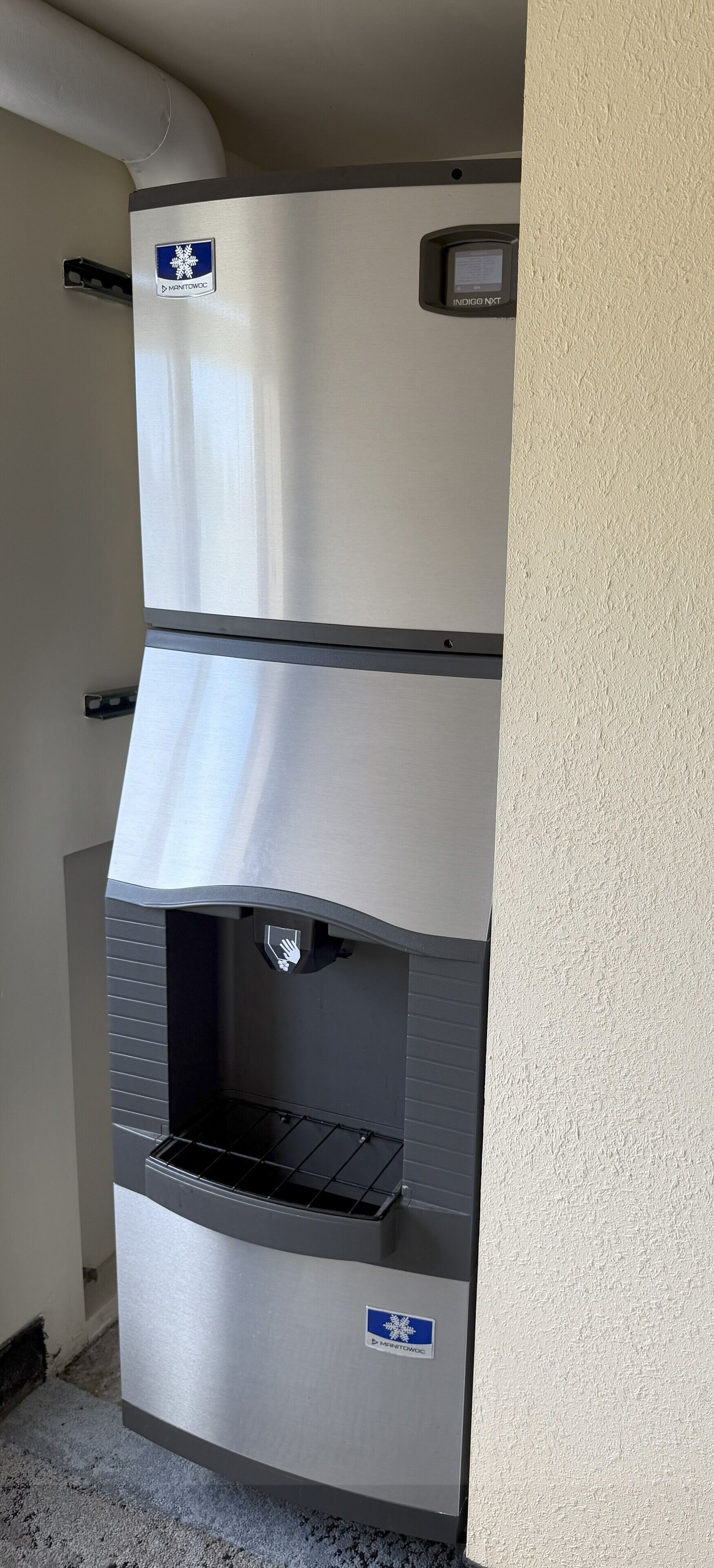 A stainless steel water dispenser with a digital display and a hand sanitizer dispenser.