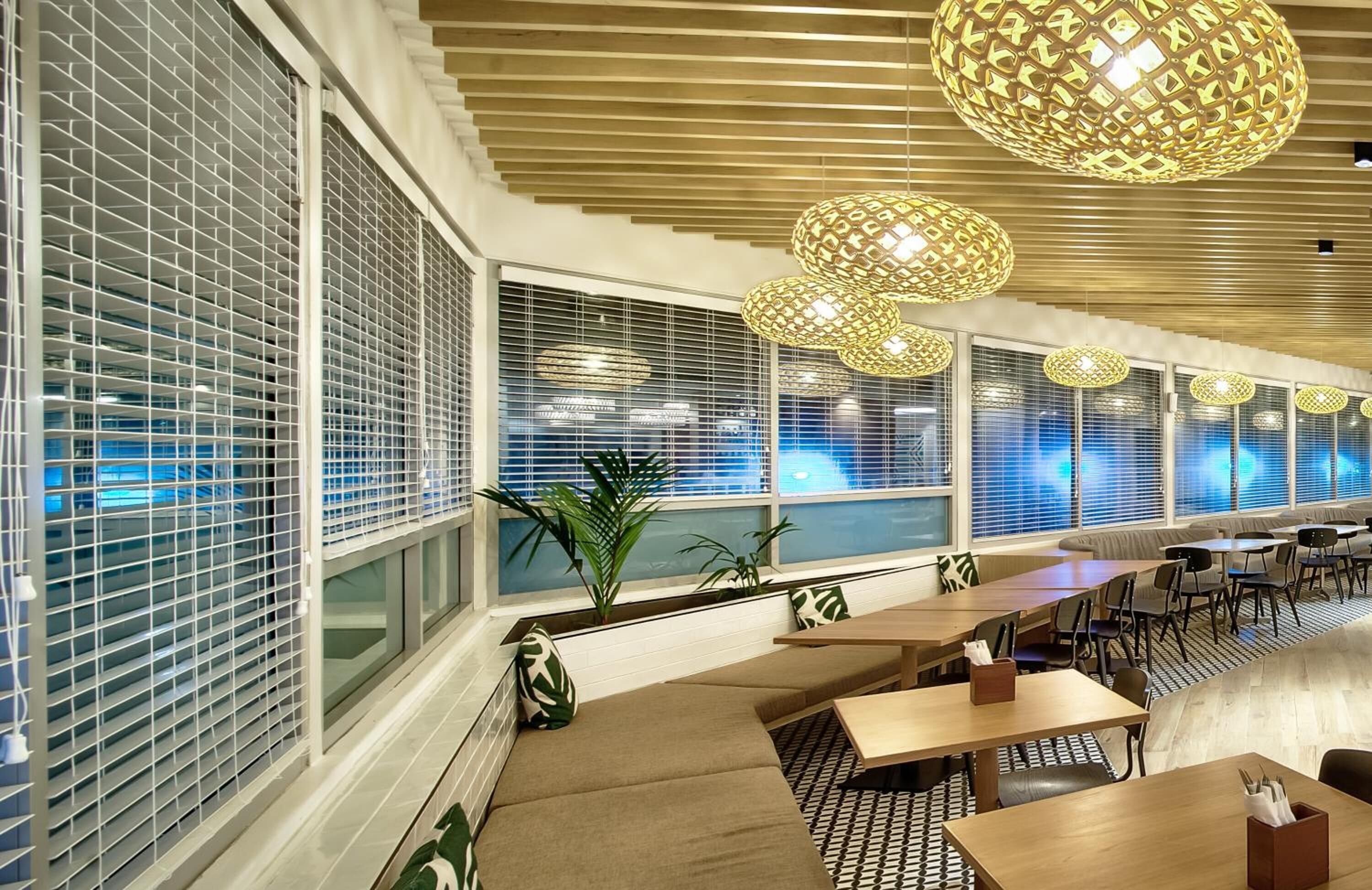 A modern interior with large windows, seating areas, and decorative spherical light fixtures.