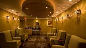 A room with a circular ceiling, two sofas, a small table, and a decorative wall. - Hilton Palm Springs Resort (Palm Springs)