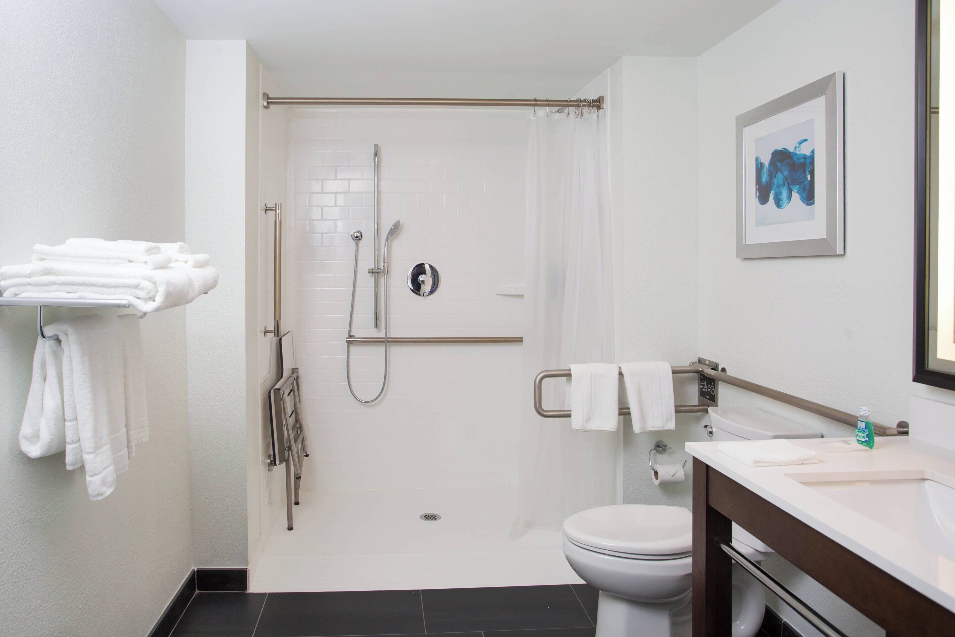 Et moderne badeværelse med brusebad, toilet og håndvask.