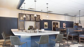 A modern bar area with a central island, bar stools, and hanging pendant lights. - Four Points by Sheraton Eastham Cape Cod (Eastham)