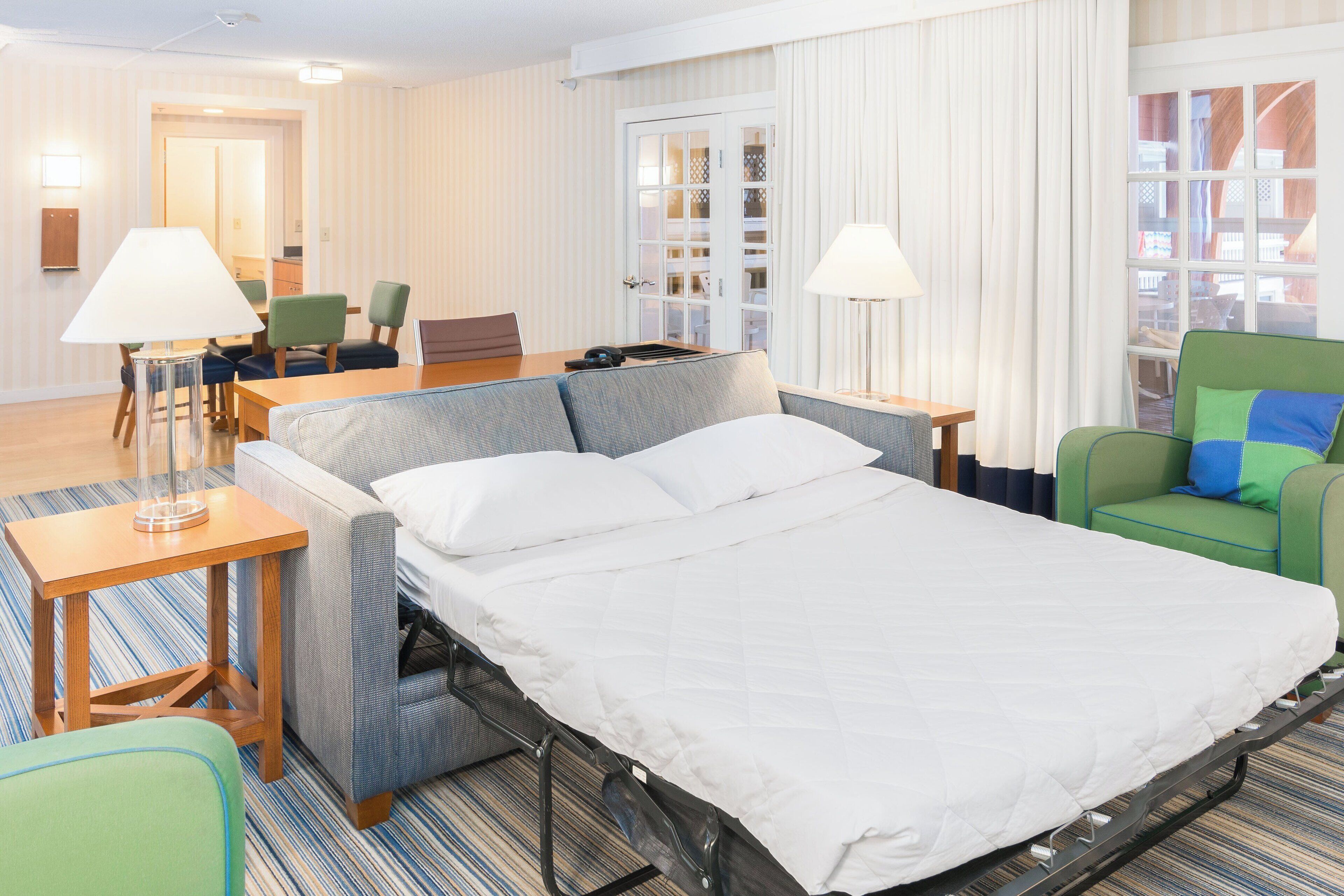 Una habitación de hotel con una cama, un escritorio, una silla y una mesita.