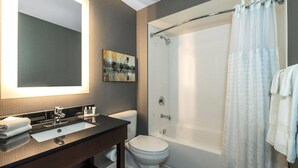 A modern bathroom with a large mirror, a bathtub, and a toilet. - Comfort Inn Dryden (Dryden)