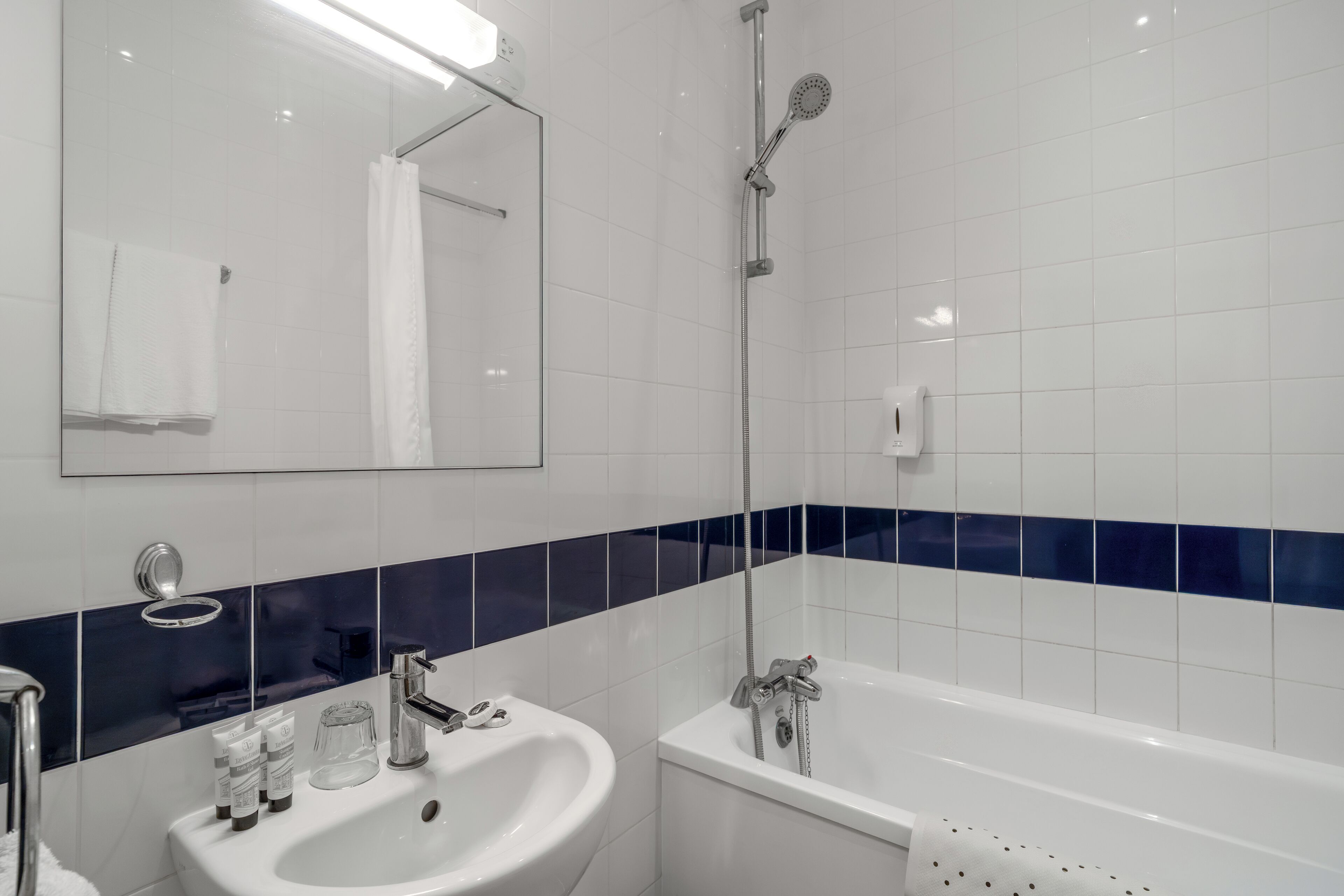 Un bagno con lavandino bianco, uno specchio, una doccia e una vasca da bagno.