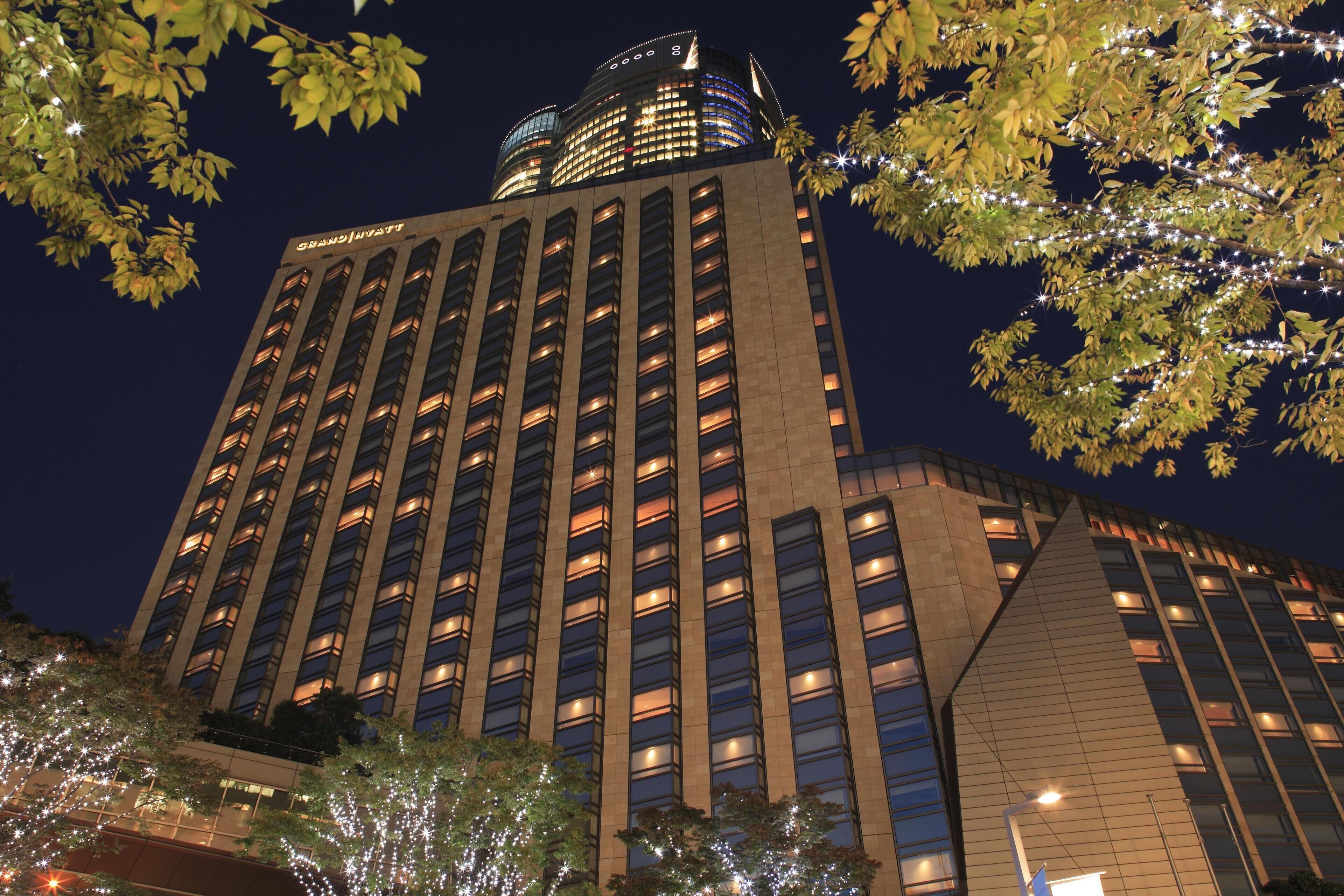 A high-rise hotel with multiple floors, illuminated windows, and a distinctive architectural design.