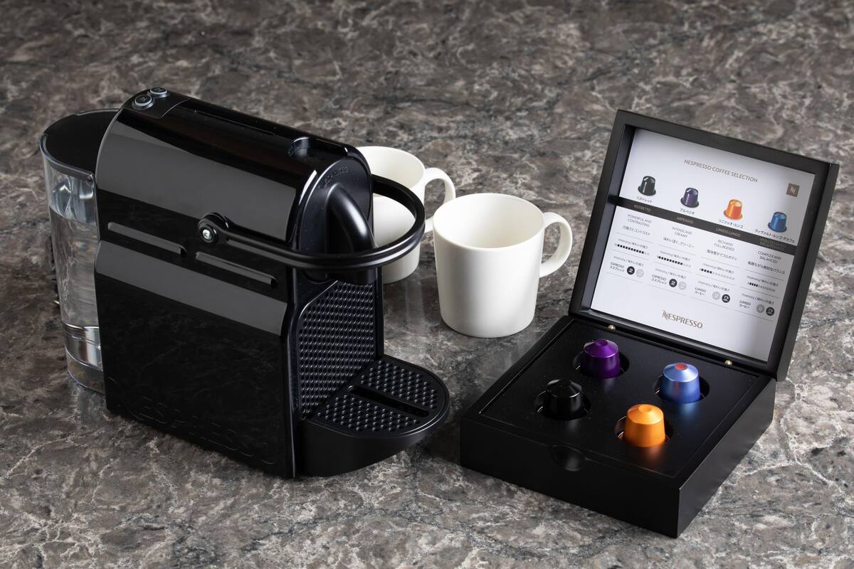 A Nespresso coffee maker with a selection guide and pods.