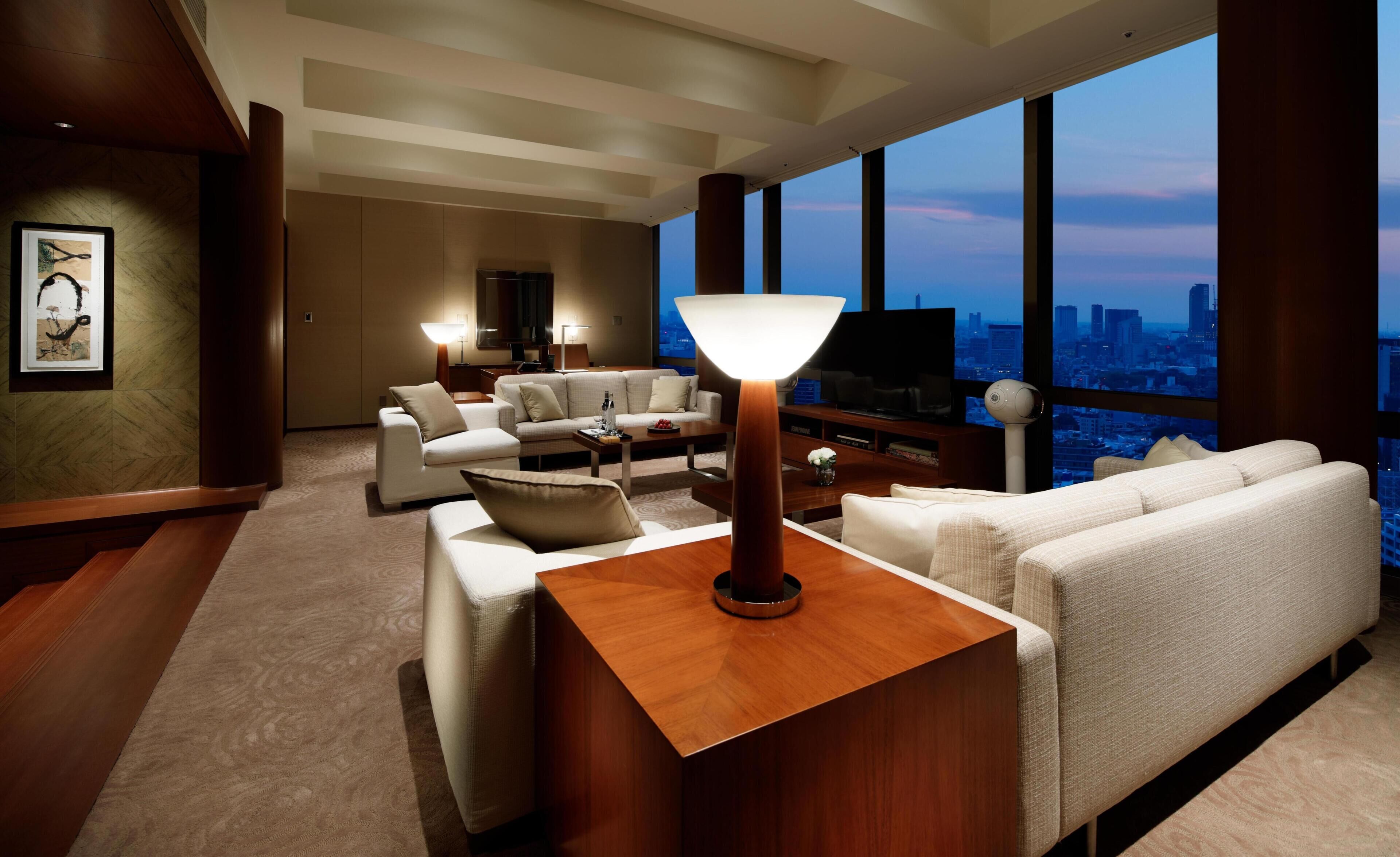 A modern living room with a large window, a flat-screen TV, and a wooden coffee table.