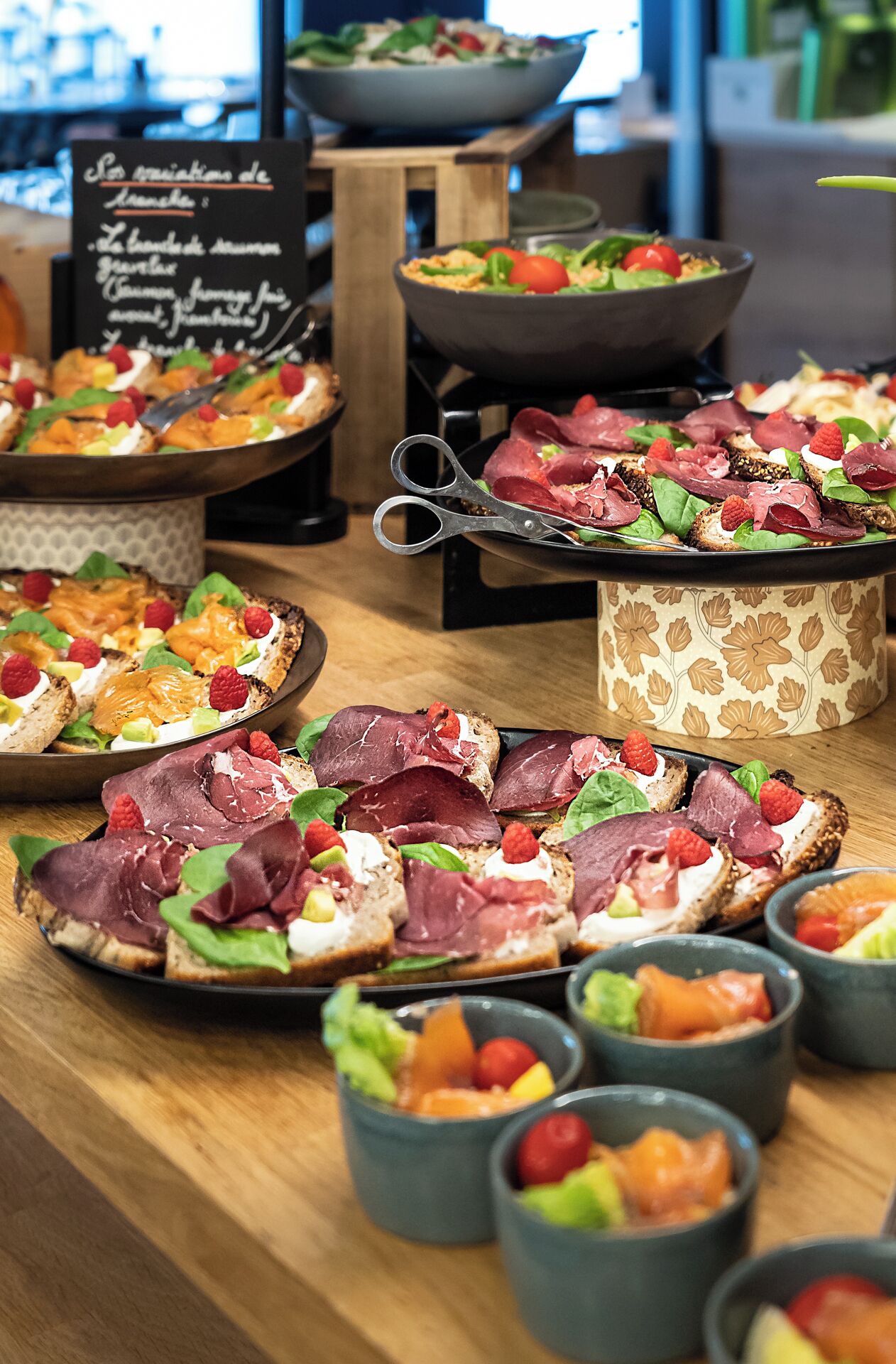 Une table de buffet proposant divers plats, notamment du pain, de la viande et des légumes.