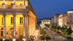 A historic building with classical architecture, a wide street in front, and a clear sky. - Mercure Bordeaux Centre Ville (Bordeaux)