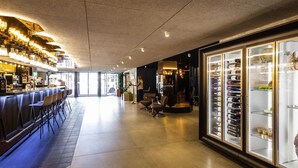 Un área de bar moderna con una barra larga, taburetes y un refrigerador para vino.