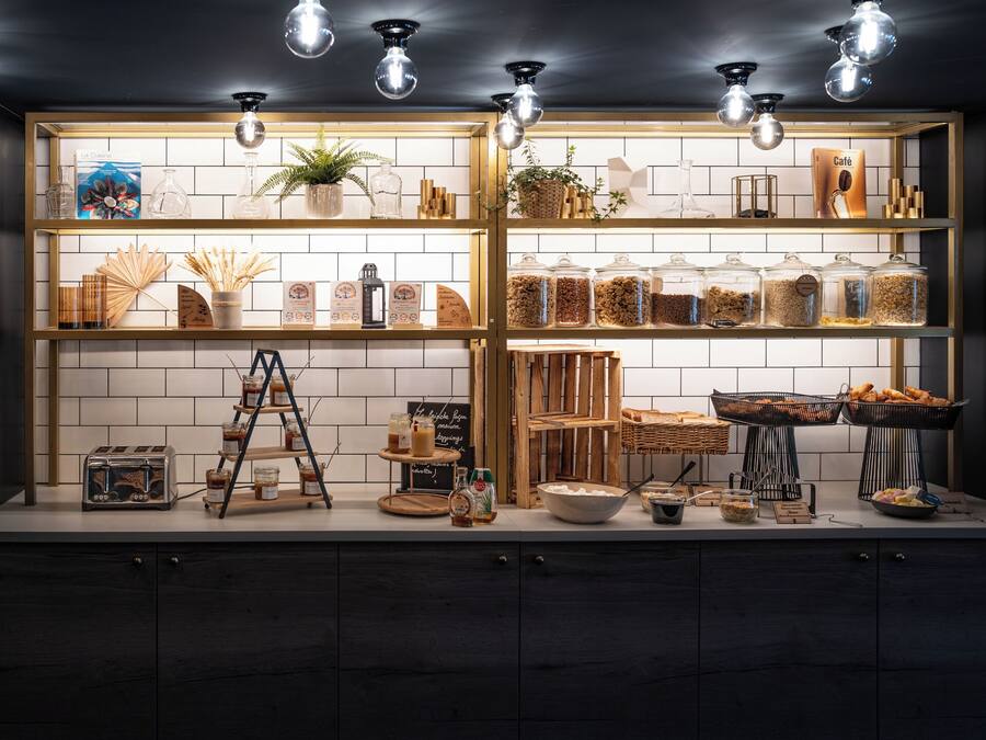 A kitchen counter with shelves containing jars of grains, a toaster, and a ladder.
