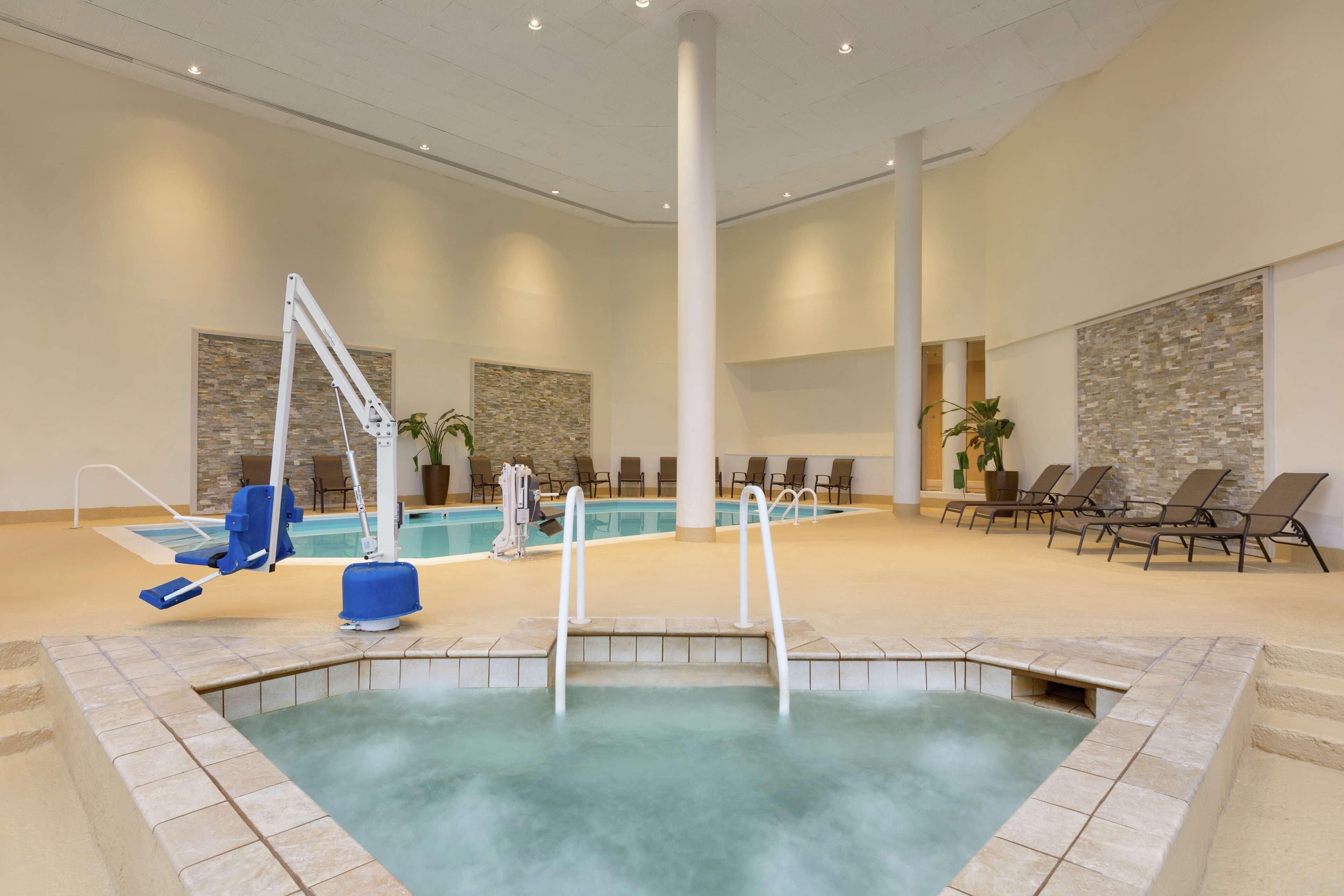 Una piscina techada, sillones reclinables de piscina