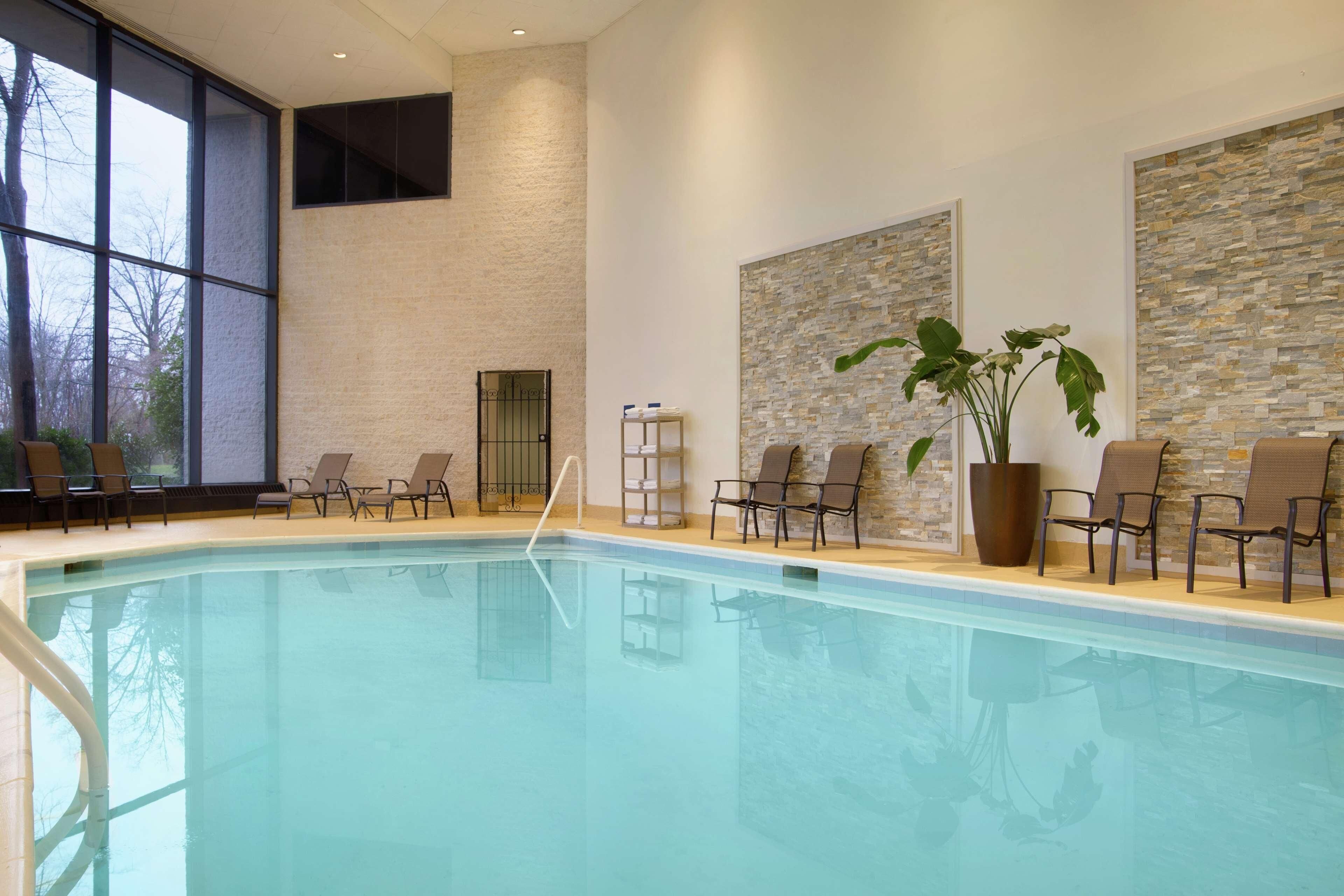 Una piscina techada, sillones reclinables de piscina