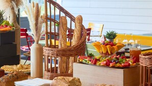Un buffet de petit-déjeuner proposant un assortiment de pains, de viennoiseries et une variété de fruits.
