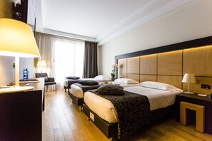 Relax in a spacious room with a large bed, desk, and comfortable chair.